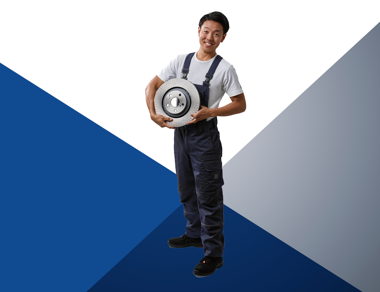 Car mechanic holding a brake discs in his arms